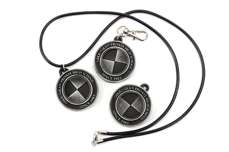 May include: Two black and silver metal pendants with the text "Gekkoukan Private High School Since 1982" on each. The pendants are attached to a black cord.