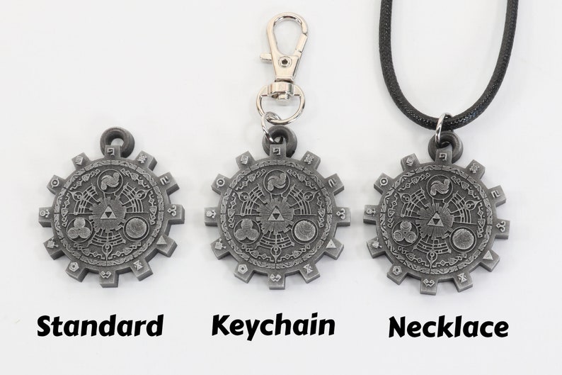 May include: Three versions of a silver-colored pendant featuring a detailed design of a Triforce symbol surrounded by a circular pattern. The pendant is available as a standard piece, a keychain, and a necklace.