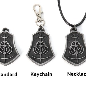 May include: Three silver pendants with a black and silver design. The pendants are shown in three different styles: standard, keychain, and necklace.