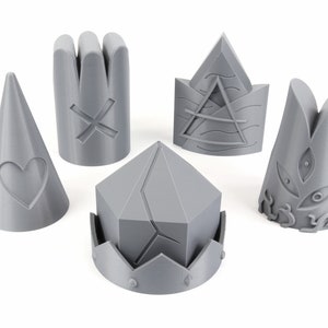 May include: Five gray 3D printed chess pieces with unique designs. The pieces include a cone with a heart, a cylinder with an X, a crown with a geometric design, a pyramid with a wave design, and a cylinder with a stylized eye design.
