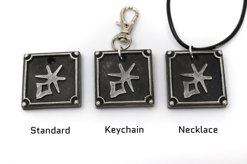 May include: Three silver-colored pendants with a black background and a silver symbol. The pendants are shown in three different styles: standard, keychain, and necklace.