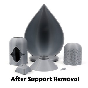 May include: A set of five gray 3D printed objects, including a teardrop-shaped bowl, a cylinder with a diamond pattern, a cylinder with a hole, a cone, and a small, flat piece.  After Support Removal.