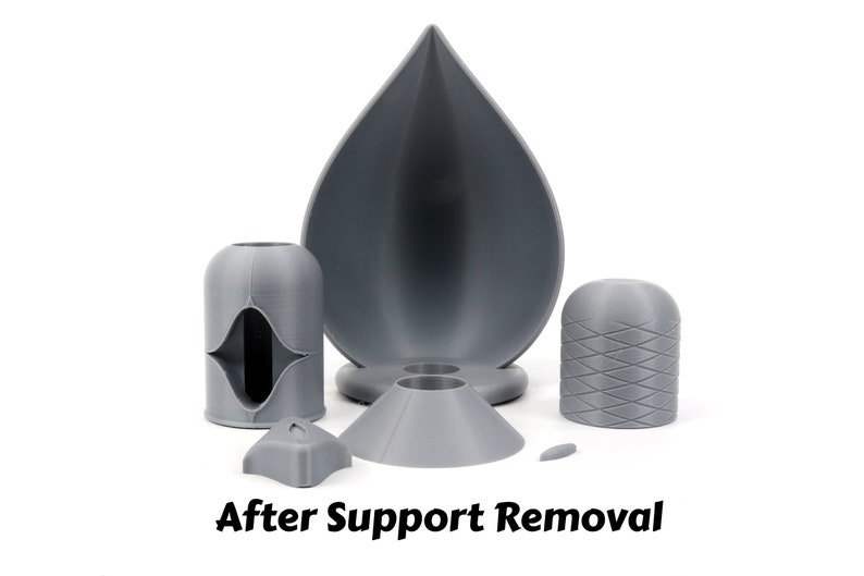 May include: A set of five gray 3D printed objects, including a teardrop-shaped bowl, a cylinder with a diamond pattern, a cylinder with a hole, a cone, and a small, flat piece.  After Support Removal.