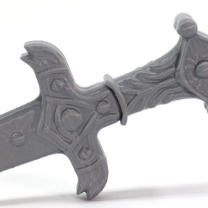 May include: A gray plastic sword with a detailed handle and a sharp point. The handle has a decorative design with a raised center piece.