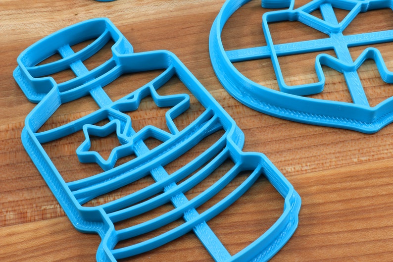 Puede incluir: Cortadores de galletas de pl&aacute;stico azul en forma de frasco con estrellas y un c&iacute;rculo con una estrella en su interior.