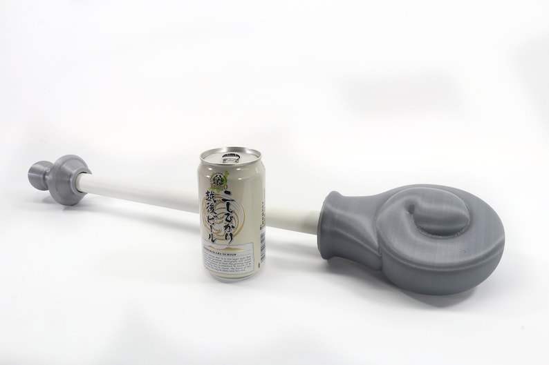 K&ouml;nnte beinhalten: Ein graues 3D-gedrucktes Objekt mit einem wei&szlig;en Stab und einer Dose japanischen Biers. Das Objekt hat ein abgerundetes Ende und ein zylindrisches Ende. Die Bierdose ist silber und beige mit japanischem Text.
