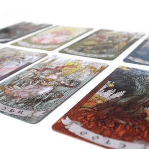 May include: A set of tarot cards with colorful illustrations and intricate designs. The cards are laid out in a fan shape, revealing various scenes and characters. The cards are printed on high-quality cardstock and feature a matte finish.