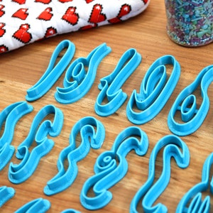 May include: A set of blue plastic cookie cutters shaped like the letters "Love" in a cursive font.