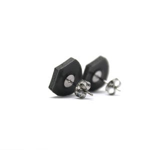 May include: A pair of black hexagonal stud earrings with silver posts.