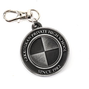 May include: A silver keychain with a round charm featuring the text "Gekkoukan Private High School Since 1982" and a black and silver quartered circle design.