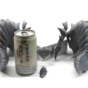 May include: Three gray 3D printed dragon wings, one with a base, and a can of Japanese beer with the text "Ichiro  Ichiban  Koshihikari  Brewed  Rice  Beer" on the label.