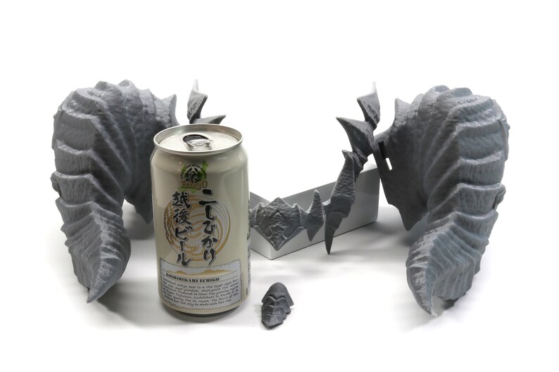 May include: Three gray 3D printed dragon wings, one with a base, and a can of Japanese beer with the text "Ichiro  Ichiban  Koshihikari  Brewed  Rice  Beer" on the label.