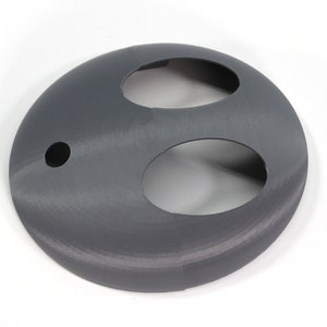 May include: A gray plastic 3D printed object with two oval-shaped cutouts and a small round hole.
