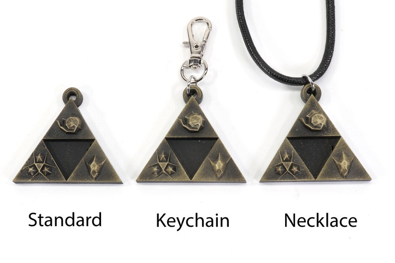 May include: Three versions of a gold-colored triangular pendant with a black center and various symbols. The pendant is available as a standard piece, a keychain, and a necklace.