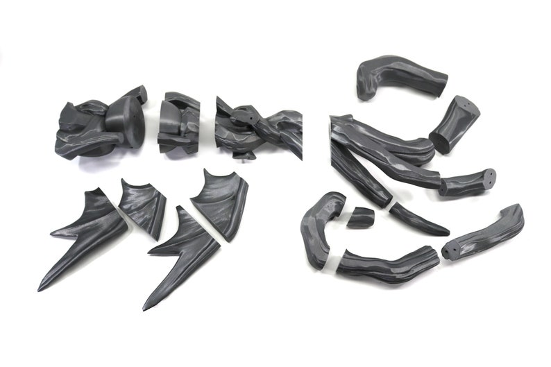 Puede incluir: Un conjunto de piezas de pl&aacute;stico gris para ensamblar un modelo de drag&oacute;n. Las piezas incluyen las alas, las patas, la cola y la cabeza.