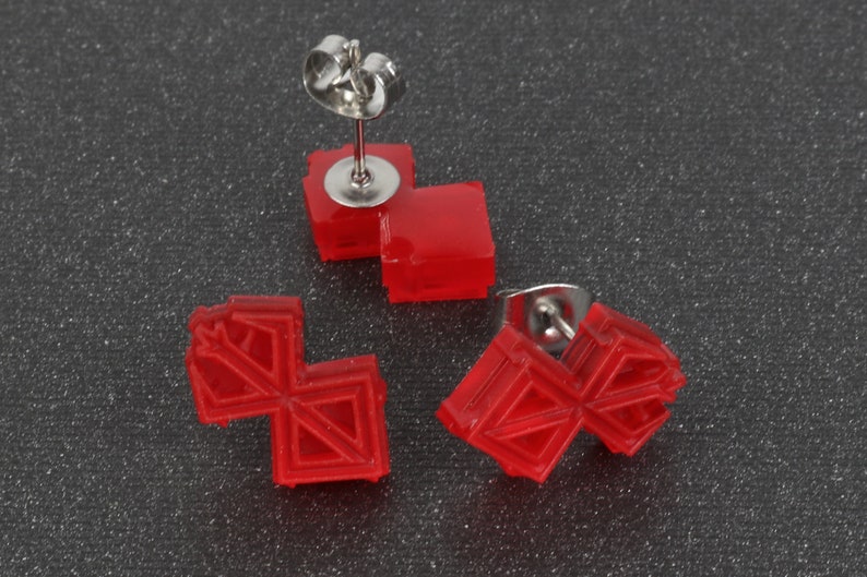 Puede incluir: Tres pares de pendientes de bot&oacute;n rojos geom&eacute;tricos con postes plateados. Los pendientes est&aacute;n hechos de pl&aacute;stico y tienen un dise&ntilde;o 3D.