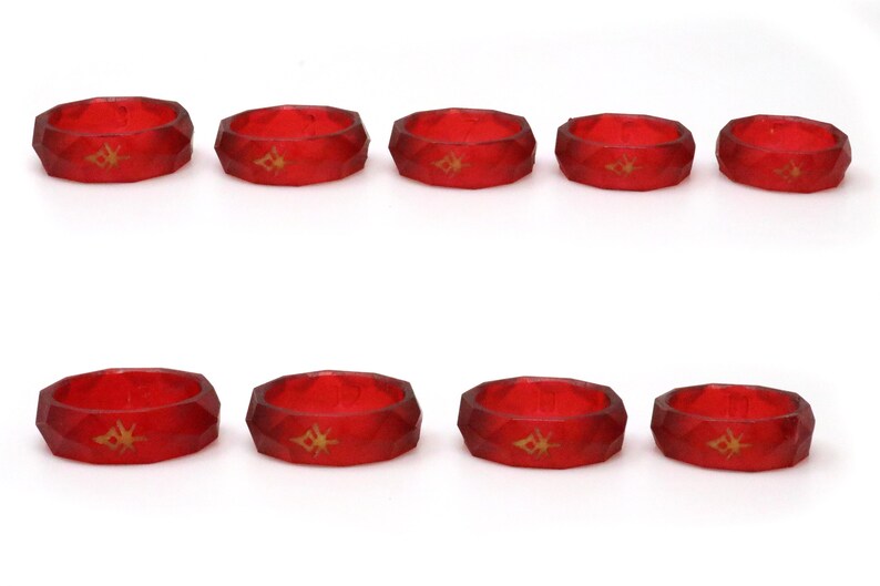 May include: Ten red silicone rings with a gold geometric design. The rings are all the same size and shape.
