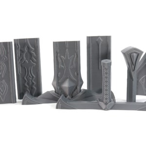 May include: A set of gray plastic pieces for building a model sword. The pieces include the blade, hilt, and pommel. The pieces are detailed with intricate designs.