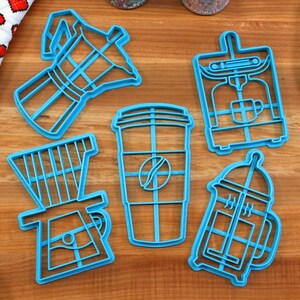 May include: Set of six blue plastic cookie cutters shaped like different coffee brewing methods: a French press, a coffee pot, a pour-over coffee maker, a coffee cup, an espresso machine, and a Moka pot.