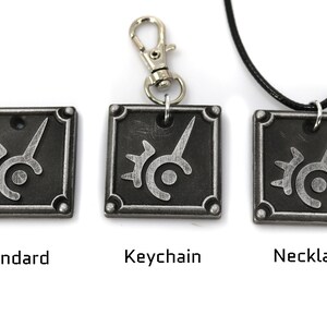 May include: Three versions of a silver metal pendant featuring the Final Fantasy VII logo. The pendant is available as a standard charm, a keychain, and a necklace.