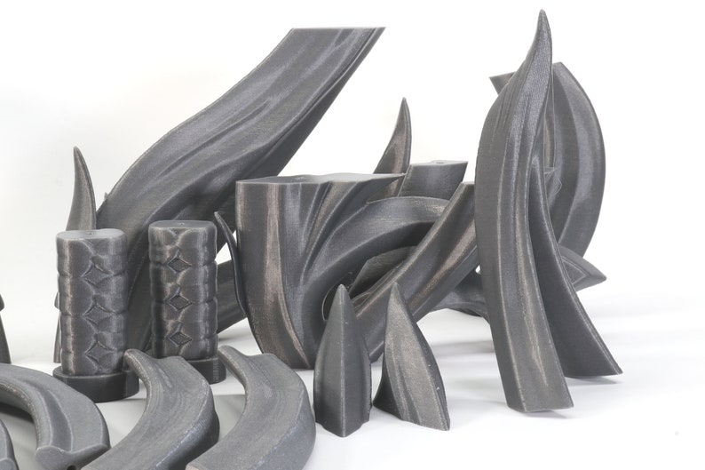 May include: A set of 3D printed, gray, abstract, geometric shapes. The shapes are made of a smooth, textured material and have a variety of curves and angles.