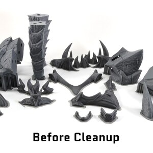 May include: A set of 14 gray 3D printed plastic pieces for a model kit. The pieces are in various shapes and sizes, including spikes, horns, and a tall, segmented tower. The pieces are arranged on a white surface. The text "Before Cleanup" is visible at the bottom of the image.