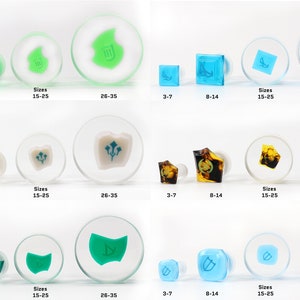 May include: Set of four different ear gauges with various designs and colors. The gauges are made of clear acrylic with a variety of colors and designs. The designs include a leaf, a shield, a flower, and a geometric shape. The gauges are available in four sizes: 3-7, 8-14, 15-25, and 26-35.