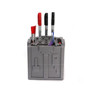 May include: A gray 3D printed pen holder with four compartments. The holder has a red, black, and blue marker in it. The holder is on a white background.