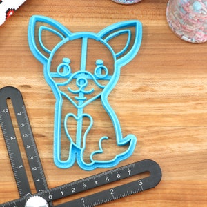 Puede incluir: Un cortador de galletas de pl&aacute;stico azul claro con forma de chihuahua con un coraz&oacute;n en el pecho.