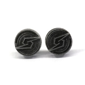 May include: A pair of silver-coloured earrings with a black, stylised lightning bolt design.