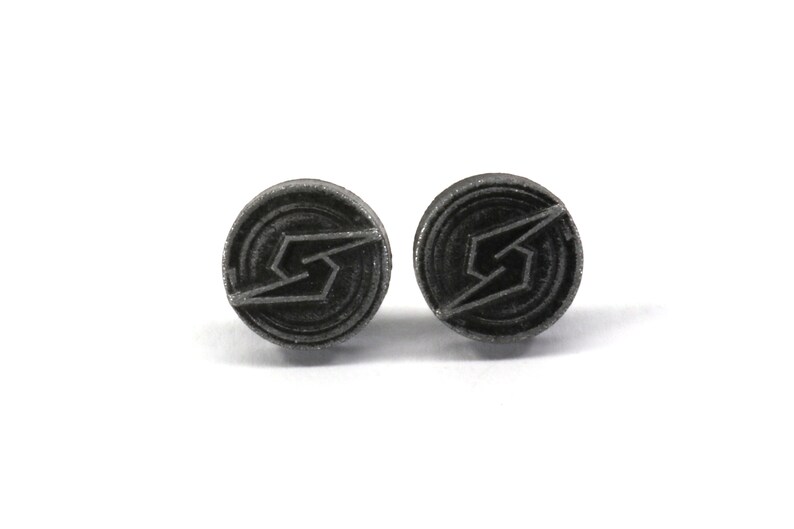 May include: A pair of silver-coloured earrings with a black, stylised lightning bolt design.