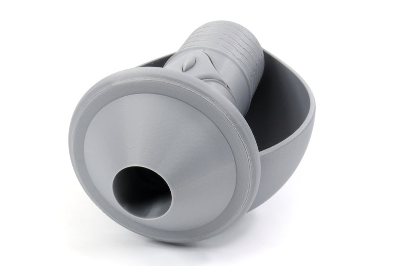 May include: A gray plastic funnel with a round base and a cylindrical spout. The funnel is designed to fit into a round container.