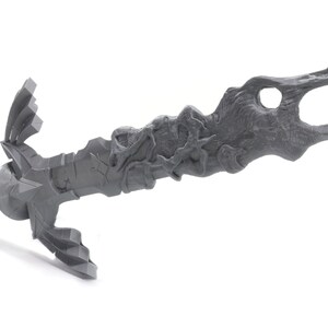 May include: A gray 3D printed sword with a detailed, organic design. The blade is curved and has a textured surface. The hilt is also detailed and has a sharp point.