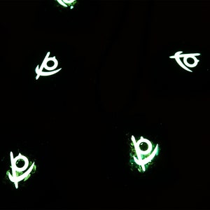May include: Five glowing green and white symbols on a black background. The symbols are stylized eyes with a curved line extending from the bottom.