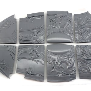 May include: Eight gray plastic pieces of a 3D printed model of a shield with a decorative design.