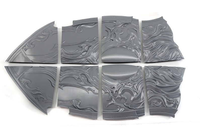 May include: Eight gray plastic pieces of a 3D printed model of a shield with a decorative design.