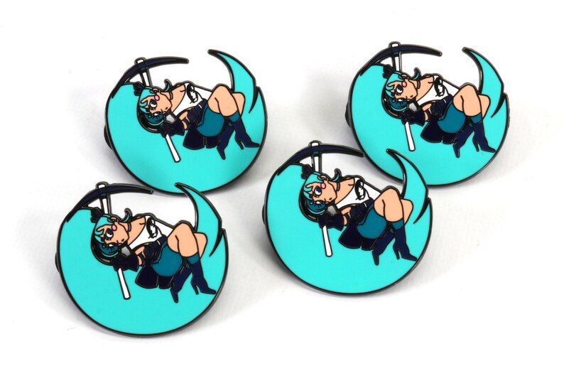 May include: Four teal blue and black enamel pins featuring a cartoon character with long teal blue hair sitting on a crescent moon. The character is holding a black scythe.