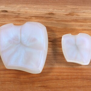 Pu&ograve; includere: Due stampi in ceramica bianca opaca a forma di denti. Lo stampo pi&ugrave; grande &egrave; a sinistra e quello pi&ugrave; piccolo a destra. Entrambi gli stampi sono su una superficie di legno.