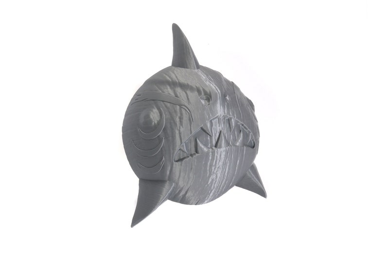 May include: A gray 3D printed shark head sculpture with a textured surface and detailed teeth.