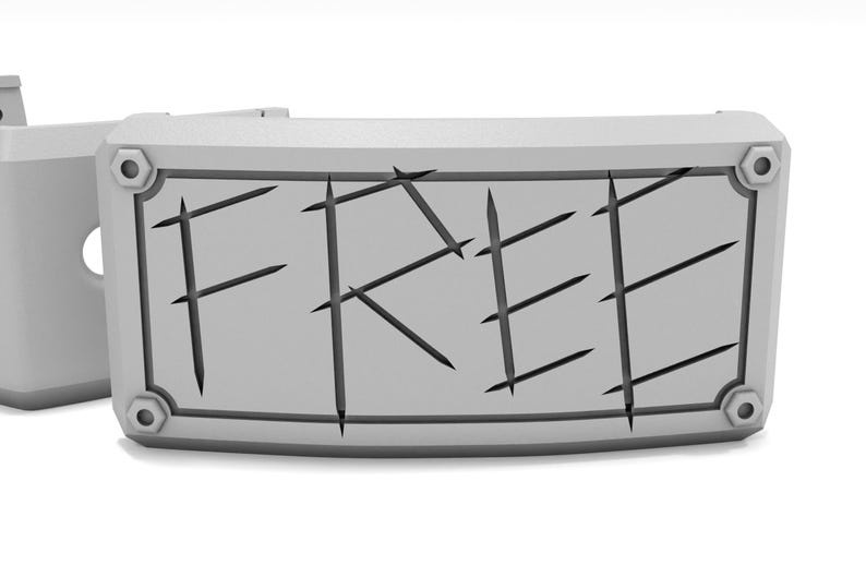 May include: A gray rectangular sign with the word "FREE" carved into it. The sign has a decorative border and is attached to a larger gray structure. The text is cut into the sign.