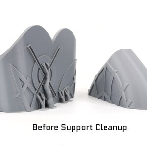 May include: Two gray 3D-printed objects, one with a curved shape and the other with a more complex design featuring a central figure and geometric patterns. The text "Before Support Cleanup" is visible at the bottom of the image.