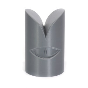 May include: A grey 3D printed sculpture of a stylised eye with a single pupil.