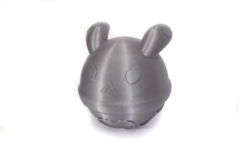 Op de afbeelding: Een grijs, 3D-geprint speelgoed in de vorm van een rond dier met grote oren. Het speelgoed heeft een getextureerd oppervlak en een eenvoudig ontwerp.