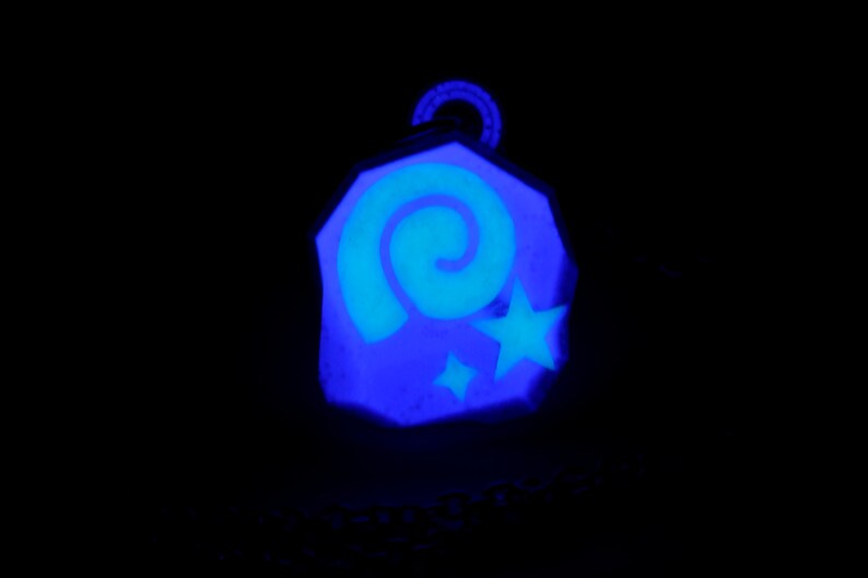 May include: A blue and white glow-in-the-dark charm with a spiral and stars design.