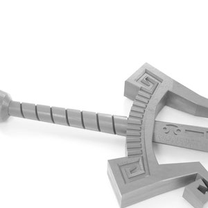 May include: A silver-coloured sword with a twisted handle and a decorative design on the blade. The sword is lying on a white surface.