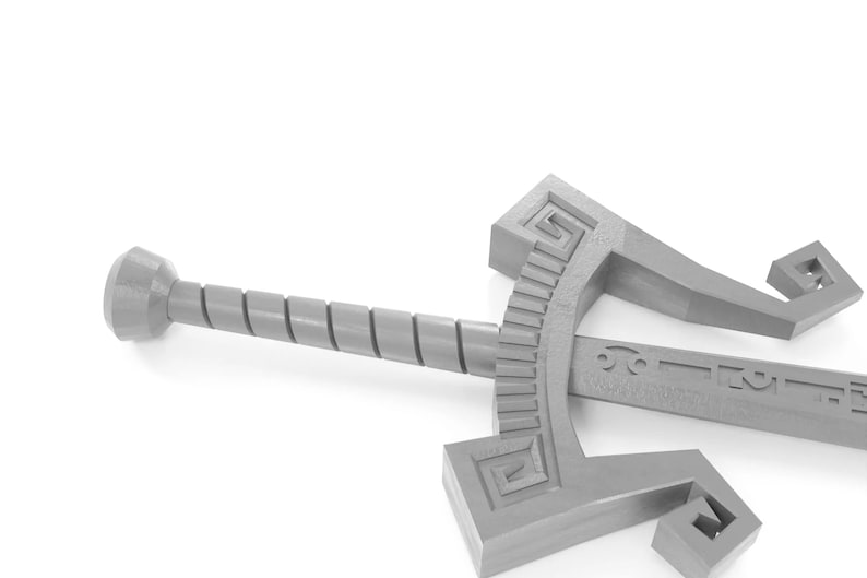 May include: A silver-coloured sword with a twisted handle and a decorative design on the blade. The sword is lying on a white surface.