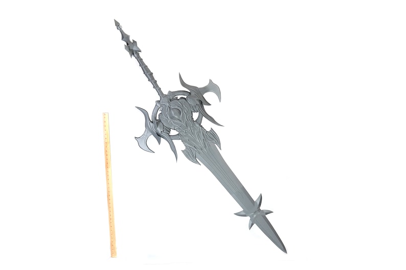 May include: A large, silver-colored sword with intricate details and a sharp point. The sword has a long, straight blade and a complex hilt with multiple points.