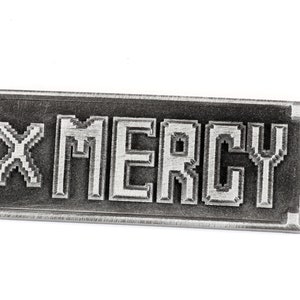 May include: A silver metal keychain with the text "X MERCY" in a pixelated font.