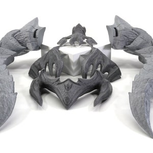 May include: A set of five gray 3D printed pieces that form a dragon-like creature. The pieces include two wings, a head, and two claws.