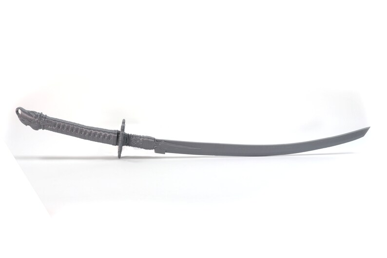 May include: A gray metal sword with a curved blade and a detailed handle.